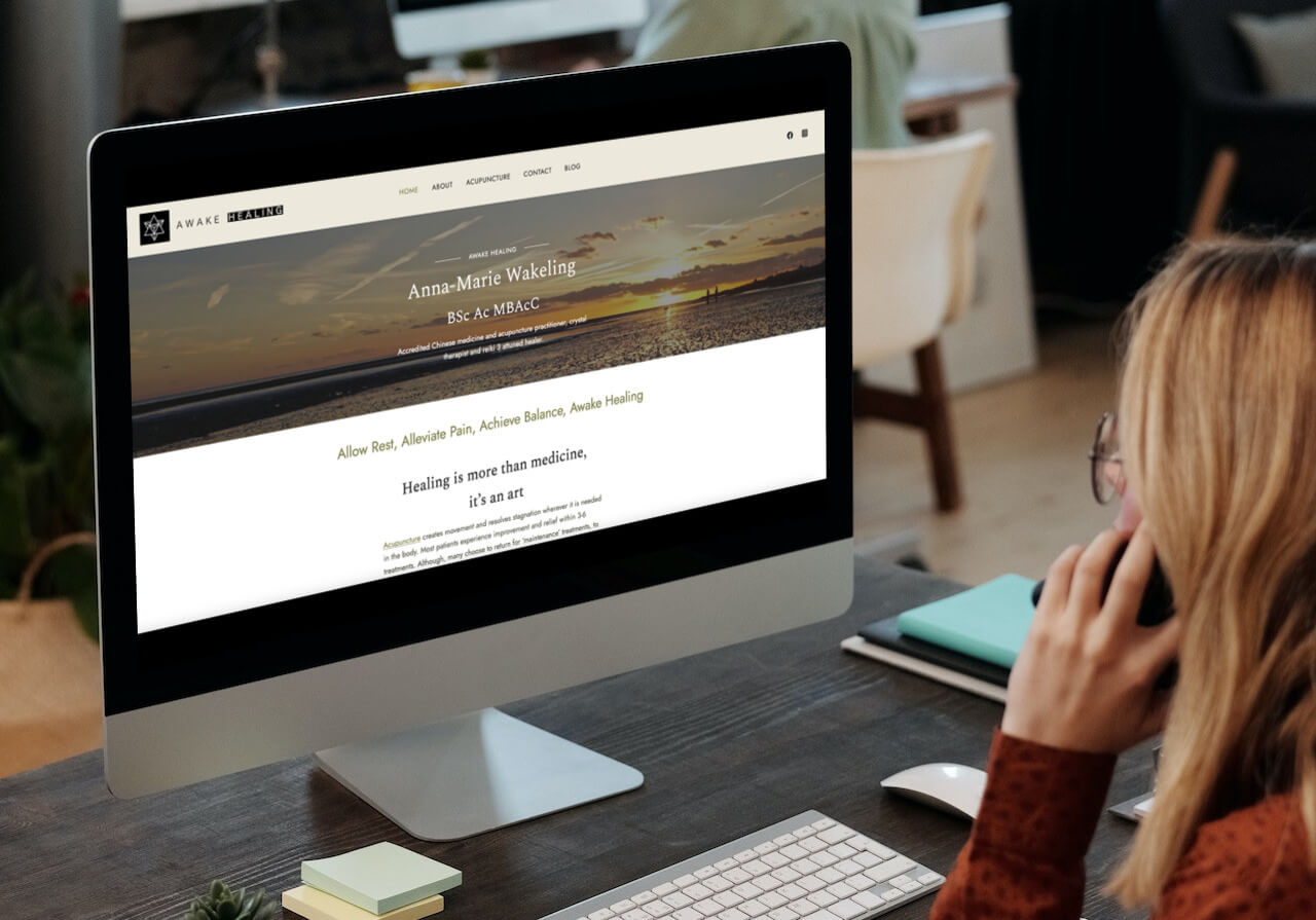 image of imac screen with Awake Healing website displayed